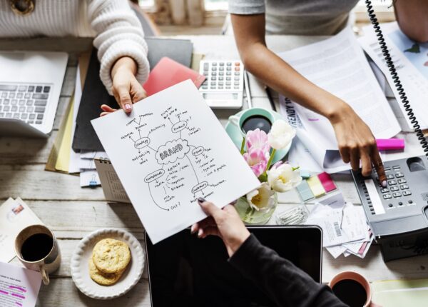 Colleagues Handing Branding Plan Strategy to other
